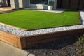 Artificial grass lawn turf with wooden edging in the front yard of a modern Australian home. Royalty Free Stock Photo