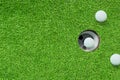 One of white golf balls in hole on green grass meadow field. Royalty Free Stock Photo