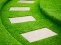 Artificial green grass walk way with concrete plate Royalty Free Stock Photo