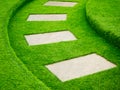 Artificial green grass walk way with concrete plate Royalty Free Stock Photo