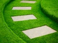 Artificial green grass walk way with concrete plate Royalty Free Stock Photo