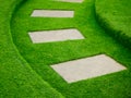 Artificial green grass walk way with concrete plate Royalty Free Stock Photo