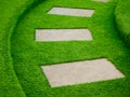 Artificial green grass walk way with concrete plate Royalty Free Stock Photo