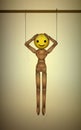 Artificial happiness concept, plastic smile concept, realistic wooden marionette hanging with artificial happy face