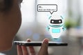 Artificial intelligence,ai chat bot concept. hands holding mobile phone on blurred abstract background. chatbot answering