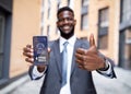 Happy black businessman in suit holding smartphone, using chatbot Royalty Free Stock Photo