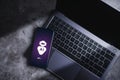 Smartphone laying on laptop displaying virtual chat with AI.