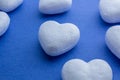 Artificial love concept, frozen heart. Valentine`s Day. White 3d polystyrene hearts arranged in rows on bright blue background