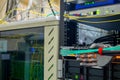 An artificial metal arm performs work in the server room. The robot switches the wires in the data center