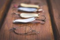 artificial metal baits on a wooden background. Homemade fishing gear.