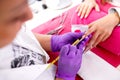 Artificial nail enhancement being applied by the hands of an experienced manicure salon worker