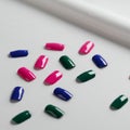 Artificial nails displayed on a white surface. The nails are glossy and feature three Royalty Free Stock Photo