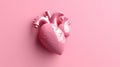 Artificial pink plastic heart model on pink background. 3d printed models of