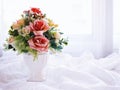 Artificial pink rose flowers bouquet in vase on white embroidered cloth copy space text or writing pretty background or wallpaper Royalty Free Stock Photo