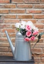 Artificial rose in metal vase.