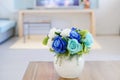 Artificial roses bouquet in ceramic vase on table in living room