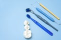 Artificial teeth with caries and toothbrush with dental tools lie on a blue background Royalty Free Stock Photo