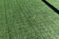 Artificial turf on football soccer field. Green synthetic grass on sport ground with shadow from soccer goal net. Top Royalty Free Stock Photo