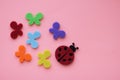 Ladybug and multicolored butterflies on pink paper