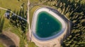 Artificial water catchment reservoir for snow skiing slopes at Dolomites, Italy