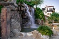 Artificial waterfall from a stone wall on the tourist embankment in Alanya Turkey. Decorative natural fountain on promenade near