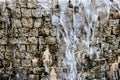 Artificial waterfall. Water stream fall down in front of ancient brick wall imitation Royalty Free Stock Photo