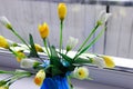 Artificial yellow tulip flowers at blue vase Royalty Free Stock Photo