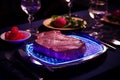 Artificially cultivated meat fillet garnished on a plate with elegant restaurant decor, neon light