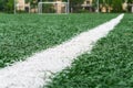 Artificially turfed football field with green grass and white line, close-up view Royalty Free Stock Photo