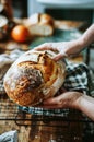 Artisan Baker Holding Freshly Baked Sourdough Bread in a Rustic Kitchen Royalty Free Stock Photo