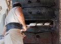 Artisan baker introducing the product in wood oven