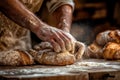An artisan baker is skillfully shaping fresh bread on a rustic wooden table in the afternoon in a cozy kitchen Royalty Free Stock Photo