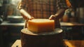 Artisan cheese maker admiring a large cheese wheel in a rustic setting Royalty Free Stock Photo