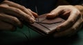 Artisan crafting leather wallet by hand with needle and thread Royalty Free Stock Photo