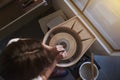 Artisan creatively shaping a clay vase in her pottery studio