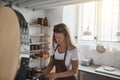 Artisan examining newly glazed pottery pieces by her workshop kiln Royalty Free Stock Photo