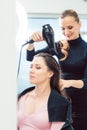 Artisan hairdresser blow drying hair of client