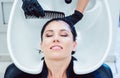 Artisan hairdresser washing hair of customer woman Royalty Free Stock Photo