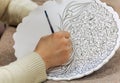 Artisan painting a pattern on ceramic dish