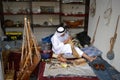 Artisan from Qatar in traditional clothes creating handmade wooden model of ships