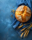 Artisan Round Bread Loaf with Wheat Ears on Blue Background, Freshly Baked Crispy Crust, Home Baked Bread, Rustic Food Photography Royalty Free Stock Photo