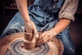Artisan sculptor works with clay on a Potter& x27;s wheel and at the table with the tools. Ceramics art concept. Close-up