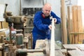 Artisan shaping timber at factory