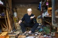Artisan showing a spinning top in his shop in the Fez Medina