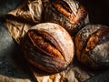 Artisan sourdough bread loaves with a rustic crust and deep scoring, displayed on crumpled paper for a bakery-style presentation Royalty Free Stock Photo
