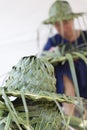 Artisan weaving palm leaf for making hat