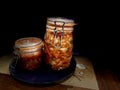 Artisanal Kimchi in Clamp-Top Jars on Dark Wooden Surface with Dramatic Lighting Royalty Free Stock Photo