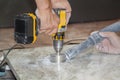 artisans cut round holes for electrical outlets in the marble countertop for the kitchen using a hand drill Royalty Free Stock Photo