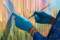 Artisans hand, adorned in blue, brings vibrant canvas to life