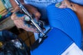 Artist with airbrush coloring a blue hat